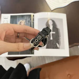 Denim fabric replacement watch strap detail shot with silver metal buckle and eyelets.