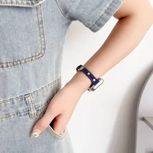 Dettaglio cinturino per orologio in denim retrò con stelle, elegante tessuto blu.