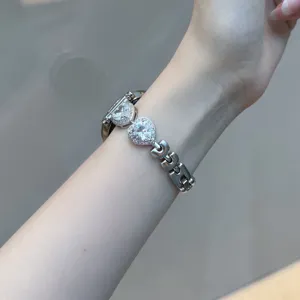 Détail de bracelet de rechange en métal pour montre connectée avec zircone cœur.