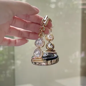 Bracelet montre connecté en métal luxueux avec zircone en forme de goutte dorée.