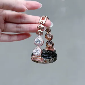 Détail du bracelet de montre connectée en métal or rose avec zircon cœur scintillant.