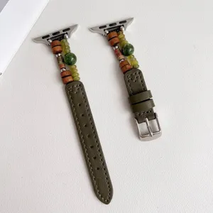 Detailopname van de groene lederen horlogeband met houten en natuurstenen kralen.