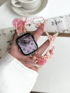 Primo piano dettagliato del cinturino in giada rosa con perle e nodi tradizionali.