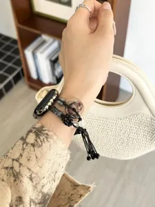 Dettaglio di un cinturino Apple Watch in stile cinese con perline e ciondolo elegante.