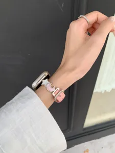 Pink leather Apple Watch strap with cute star and moon charms, stylish replacement wristband.