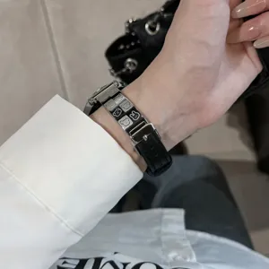 Metal leather watch strap detail featuring cute engraved cartoon character designs for smartwatches.