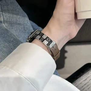 Detailed close-up view of the metal and leather spliced watch strap with cute cartoon animal patterns.
