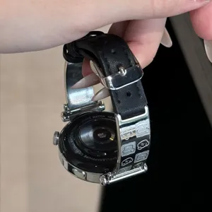 Detailed view of the metal and leather cute puppy watch strap, showing exquisite engraving.