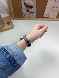 Dettaglio cinturino catena acciaio denim Apple Watch, design elegante per uso quotidiano.