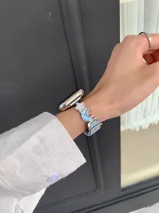 Blue leather Apple Watch strap featuring stylish star and moon metal charms for daily wear.