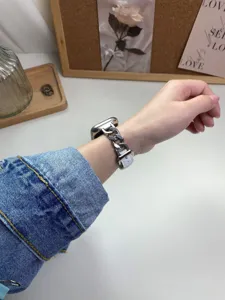 Dettaglio cinturino per orologio in pelle con catena in acciaio, stile denim per Apple Watch.