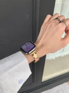 Gold metal star and moon charm watch strap detail, elegant accessory for smart watch.