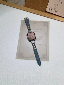 Vista di dettaglio dell'elegante cinturino in denim e catena di metallo per orologi.