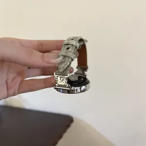 Denim smartwatch strap detail, featuring cute bear charm and sturdy metal buckle.