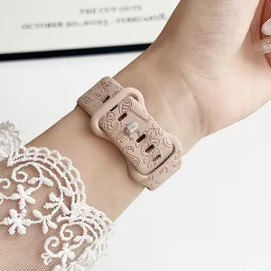 Detailaufnahme des Silikon-Uhrenarmbands mit Blumen- und Flamingogravur am Handgelenk.