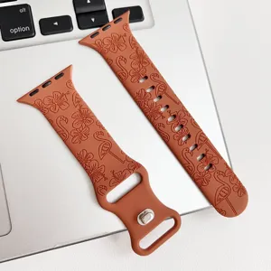 Nahaufnahme des terracottafarbenen Silikonarmbands mit geprägten Blumen- und Flamingomustern.