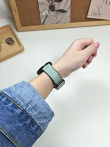 Dettaglio del cinturino per orologio in pelle e silicone verde chiaro con fibbia quadrata.