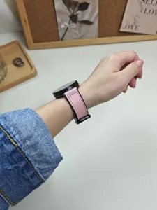 Primo piano dettagliato di un elegante cinturino per smartwatch in pelle rosa.