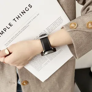 Vue détaillée du bracelet en montre en cuir avec coutures blanches et boucle en métal.