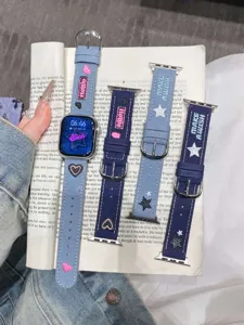 Gros plan de bracelets de montre en jean avec des étoiles et des cœurs brodés mignons.