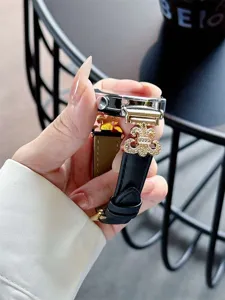Close-up detail of luxury leather smartwatch replacement band with gold cross metal charm.