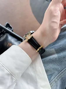 Detailed wrist shot showcasing a premium leather watch strap with a gold crystal clasp.