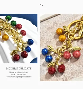 Close-up detail of colorful glitter cherry cluster bag charm with shiny alloy leaves and key ring.