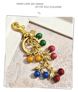 Colorful glitter cherry keychain with gold alloy leaves, cute fruit bag charm pendant.