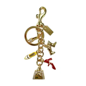 Llavero de metal dorado con elegantes colgantes de zapatos y bolsos con detalles.