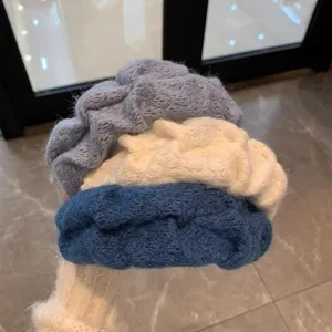 Primo piano dettaglio cerchietto in morbida maglia plissettata, design ampio e confortevole.