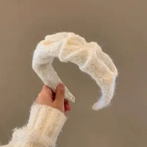 Primo piano di una fascia per capelli in morbida maglia spessa, design elegante e chic.