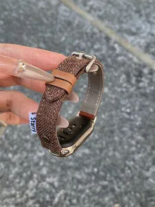 Brown woven canvas smartwatch replacement strap with leather loop and metal buckle detail.