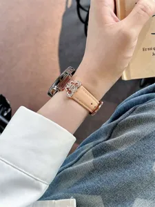Beige leather smartwatch replacement strap featuring a sparkling rhinestone metal charm detail close-up.