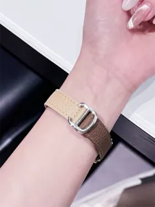 Detailansicht eines eleganten zweifarbigen Lederarmbands mit metallener Dornschließe am Handgelenk.