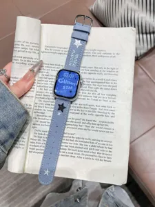 Gros plan détaillé du bracelet de montre en jean élégant avec des étoiles brodées sur livre.