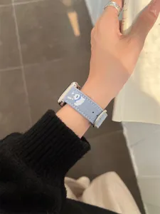 Blue denim embroidered puppy Apple Watch band, stylish denim fabric strap detail view for smart watch.