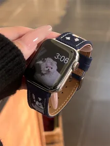 Denim embroidered watch strap detail view, cute dog pattern, stylish and durable accessory.