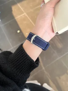 Navy blue canvas watch strap with white stitching and silver buckle, comfortable fit for daily wear.