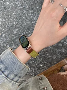 Detailed view of the stylish canvas and leather watch strap worn on wrist, showing texture.