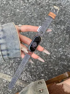 Detailed view of fashionable denim canvas watch strap with leather and metal buckle. Premium texture.