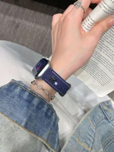 Gros plan détaillé du bracelet de montre en toile bleu foncé avec des étoiles brodées.