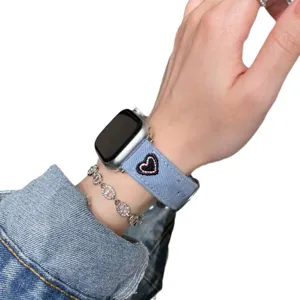 Bracelet de montre connectée en jean bleu avec motif cœur brodé, compatible Apple Watch.