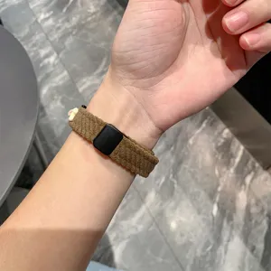 Brown corduroy smart watch strap detail showing magnetic buckle and cute bear charm on wrist.