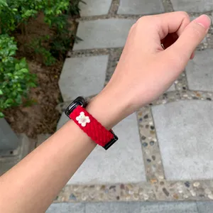 Red corduroy watch strap detail showing the soft fabric texture and cute white bear charm.