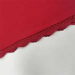 Close-up detail of women's autumn long sleeve top featuring delicate red lace trim hemline.