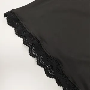 Close up view of black long sleeve top showing exquisite floral lace trim design.