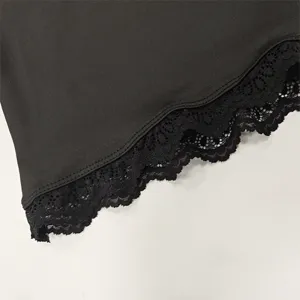 Close-up detail of women's autumn long sleeve top featuring elegant black lace hem trim.