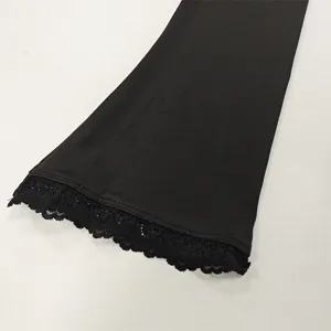 Close-up detail view of black long sleeve top featuring delicate lace trim and design.