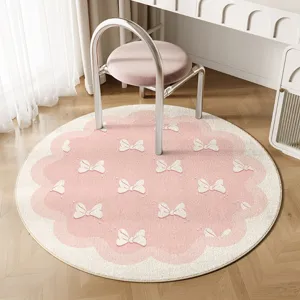 Cream pink round rug with cute white bow pattern, soft plush bedroom bedside mat and cozy decor.