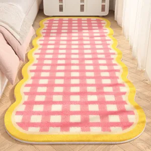 Detailed view of a soft pink and white checkered bedside rug with a cozy yellow wavy border.